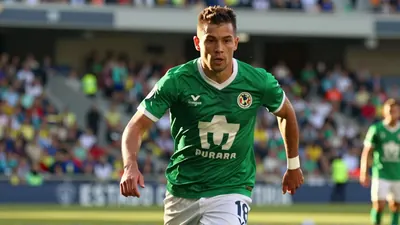 Chicote Calderón, mid-30s, athletic striker with short dark hair and focused expression, sprinting with the ball on a...